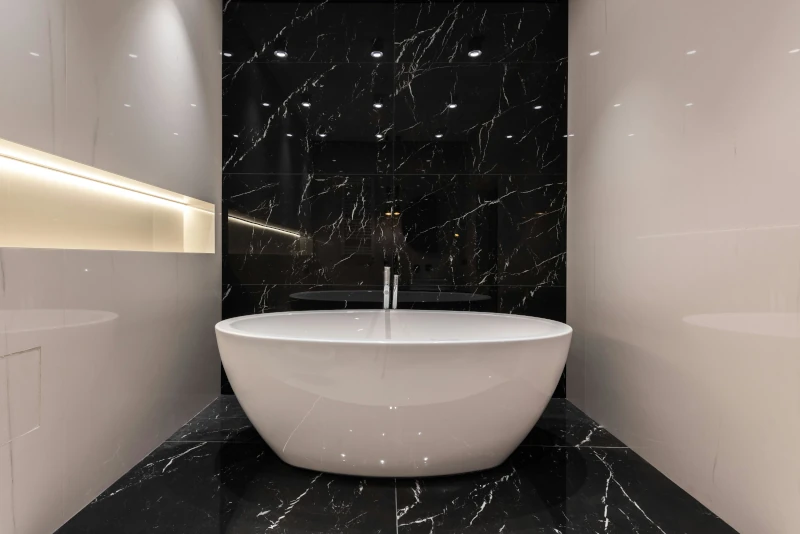 Productos Bañera exenta en espacio de baño con acabados oscuros y diseño limpio