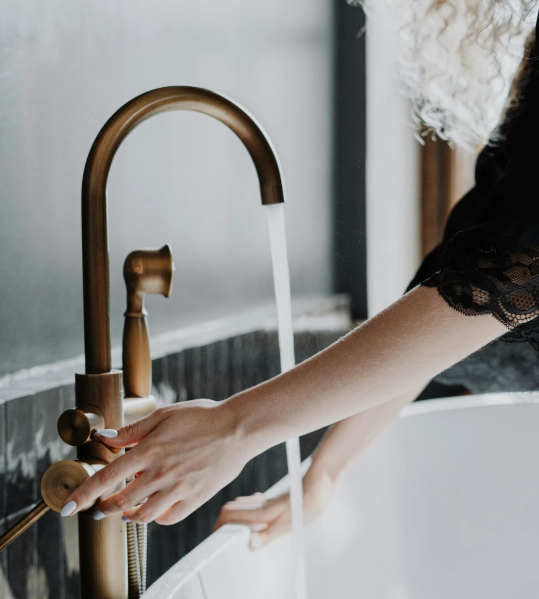 Grifería de baño de diseño europeo en acabado metálico con uso real en lavabo contemporáneo