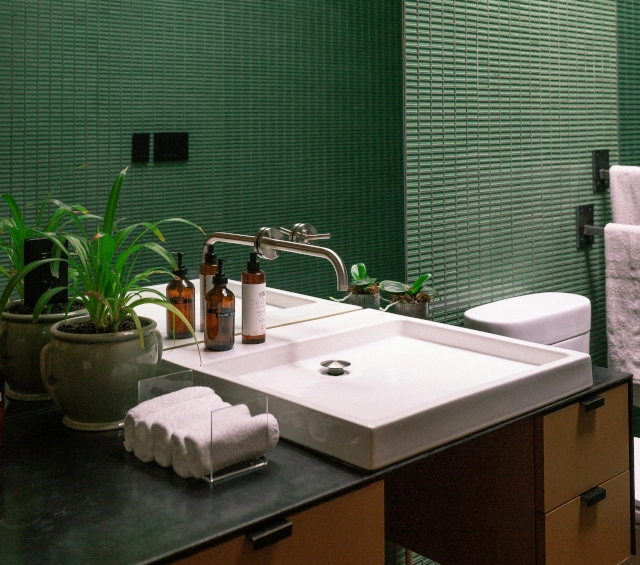 Baño contemporáneo con lavabo integrado, grifería mural y mueble de baño en acabado madera